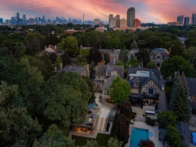 Dusk aerial of a backyard pool with the Toronto skyline