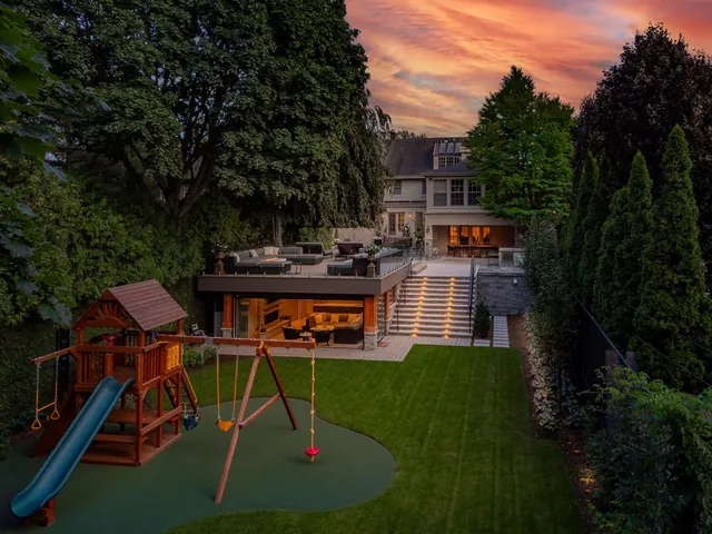 Twilight backyard with playground and house