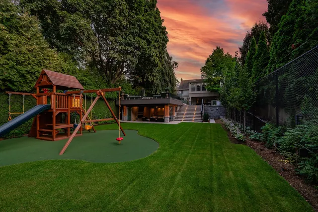 Wide twilight view of a lawn and playground